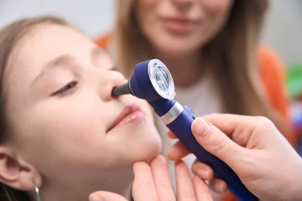 専門のツールで鼻を検査し 女の子の患者の健康をチェックするクローズアップ専門の喉科医 定期的な生徒の健康診断 — ストック写真