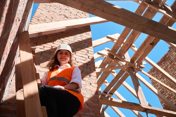はしごの上に立つ笑顔の女性プロジェクトマネージャーと建設現場を見て ハードハットの検査官建物の品質 住宅開発 — ストック写真