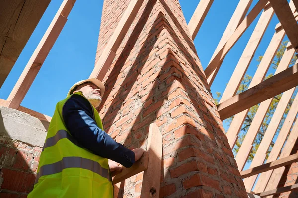 Qualifizierter Bauingenieur Steht Auf Leiter Und Betrachtet Dachbalken Begutachtet Die — Stockfoto
