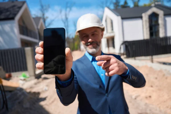 Bearded Investeerder Van Woningbouw Holding Smartphone Tonen Een Online Elektronisch — Stockfoto