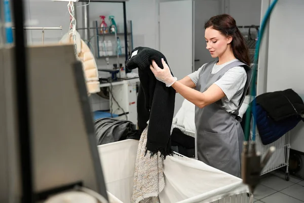 洗衣女工在干洗 预处理 专业干洗前对衣服进行检查和分类 — 图库照片