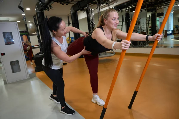 Brunette Helps Blonde Woman Perform Balance Exercises Gymnastic Sticks — Stock Photo, Image