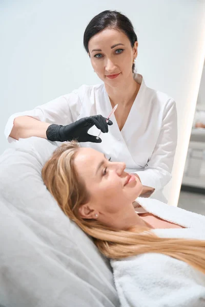 Cosmetologist Uniforme Prende Uma Seringa Para Procedimento Antienvelhecimento Injeção Suas — Fotografia de Stock