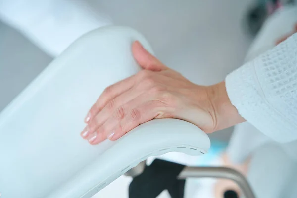 在妇科医生办公室的妇科椅子上 女性的手靠得很近 — 图库照片