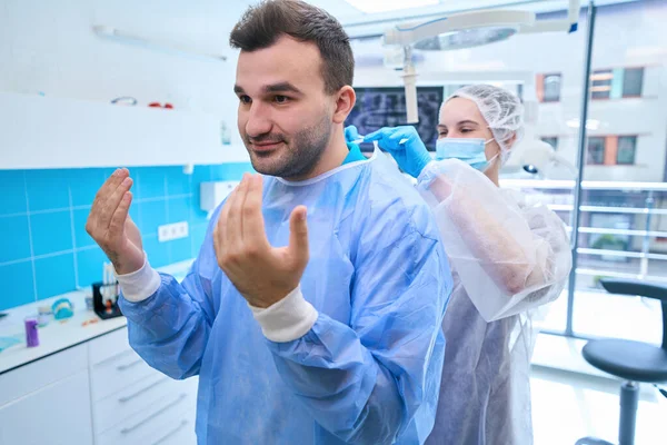 Assistentin Zieht Eine Sterile Einweg Uniform Für Den Arzt Das — Stockfoto