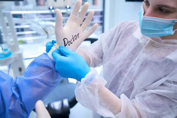 Pielęgniarka Zakłada Chirurgowi Rękawicę Jednorazowego Użytku Inskrypcją Lekarza Zespół Przygotowuje — Zdjęcie stockowe