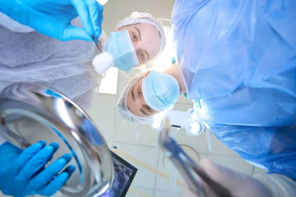 Młody Chirurg Trzyma Kleszcze Usuniętym Zębem Asystentka Pęsetę Wacikiem Rękach — Zdjęcie stockowe