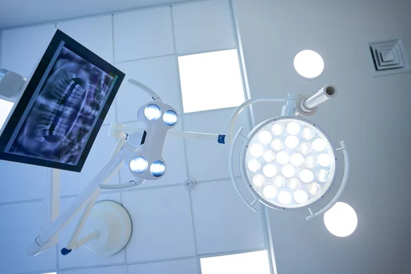 现代门诊部牙科医生工作场所用牙科X光图像的手术灯和监测器 — 图库照片