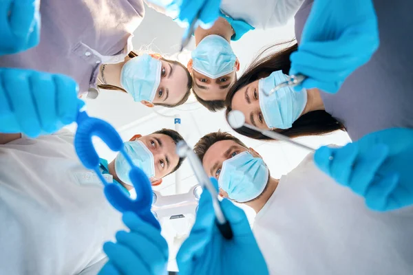 五名医生 男人和女人 手里拿着牙科器械 身穿医疗制服 戴着防护手套 — 图库照片