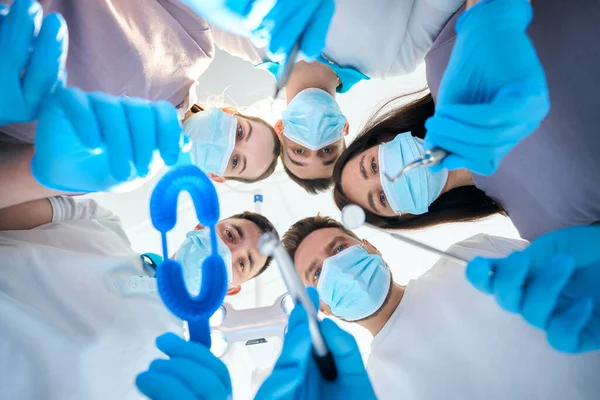 5名男子和妇女 手里拿着牙科器械 身穿医疗制服 戴着防护手套 — 图库照片