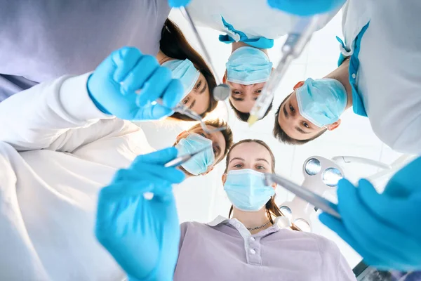 手に歯科器具を持つ若い歯科医のチーム 医療用制服の人々 — ストック写真