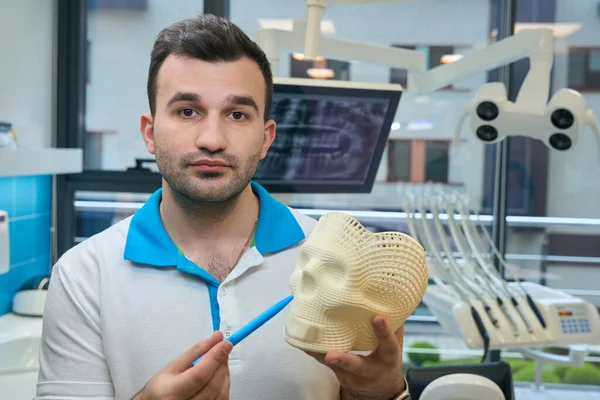 人类展示了一个颅骨模型 一个在牙科诊所工作的医生 — 图库照片