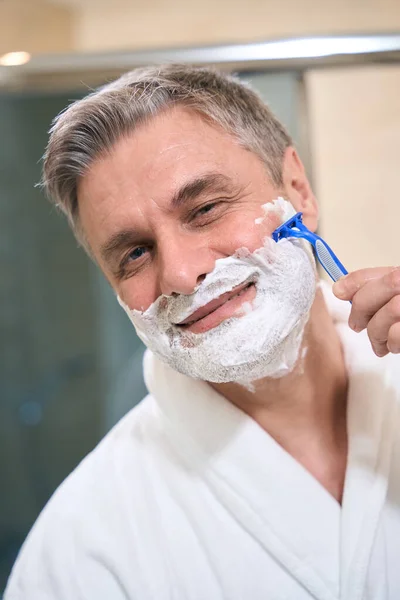 Banyoda Tıraş Olan Kameraya Bakan Beyaz Ceketli Gülümseyen Bir Erkek — Stok fotoğraf