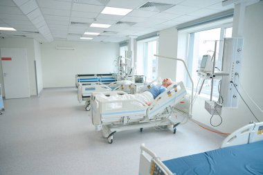 Klinikteki farklı hastane ekipmanlarıyla resüsitasyonda yatan hasta erkek hasta.