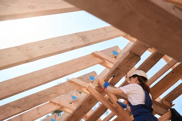 木造屋根枠に釘を打ち女性建築技術者 より安全に構造を固定 建設現場で屋根の責任 — ストック写真