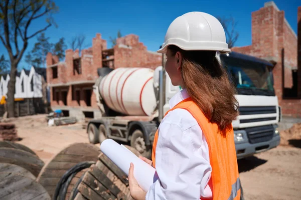 建筑过程控制硬帽行业的女建筑工程师 沿着建筑工地行走 住房开发 — 图库照片