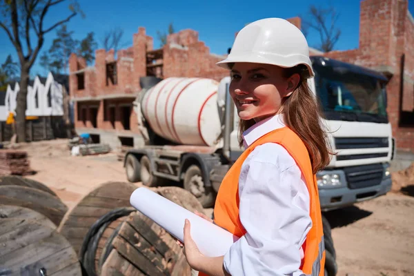 女建筑工程师控制未来房屋混凝土地基浇注 穿着便帽和安全背心在建筑工地行走 — 图库照片