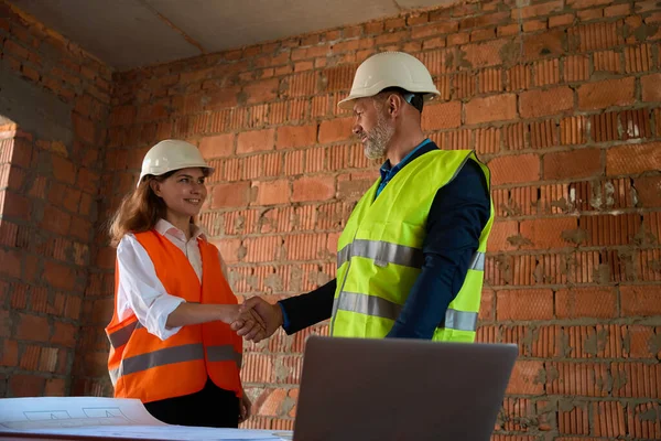 满意于质量蓝图工头与女建筑师握手 在建筑工地见面 — 图库照片