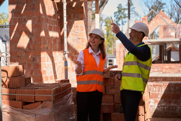 Kvinna Fastighetsmäklare Förvånad Över Byggnadskonstruktionshastighet Prata Med Foreman Spendera Tid — Stockfoto