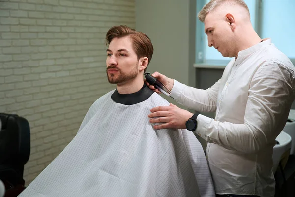 Kuafördeki Yakışıklı Adam Içeride Elektrikli Makas Kullanarak Saçını Keserken Oturuyordu — Stok fotoğraf