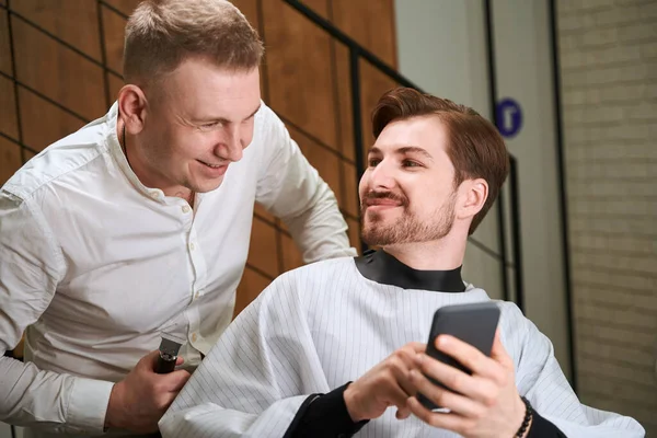 Visitatore Maschio Mostrando Mobile Guardando Barbiere Mentre Naviga Mobile All — Foto Stock