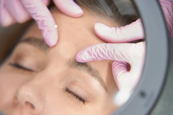 Kosmetologe Untersucht Die Gesichtshaut Des Patienten Durch Ein Vergrößerungsglas Der — Stockfoto