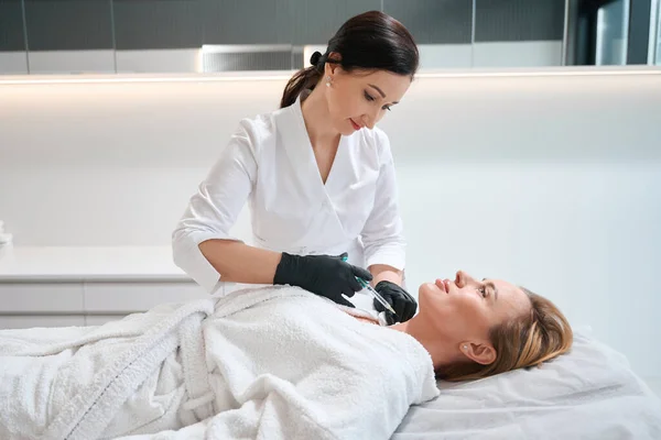 Schoonheidsspecialiste Een Kosmetologische Kliniek Injecteert Een Vrouw Nek Patiënt Ligt — Stockfoto