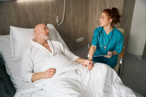 Kvinnlig Läkare Uniform Sitter Nära Manlig Patient Sängen Och Stödja — Stockfoto