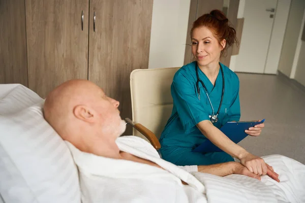 Trabalhadora Saúde Sorridente Com Prancheta Comunicando Com Seu Paciente Idoso — Fotografia de Stock