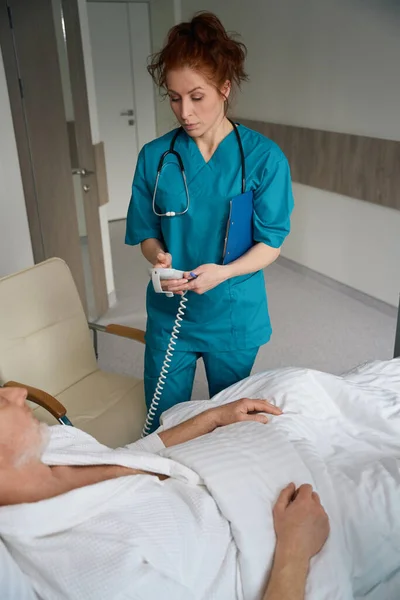 Médica Feminina Segurando Aparelho Paciente Personalizando Perto Cama Com Homem — Fotografia de Stock
