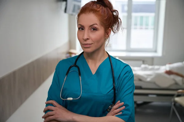 穿着制服 双臂交叉的成功女医生站在医院病房的画像 — 图库照片