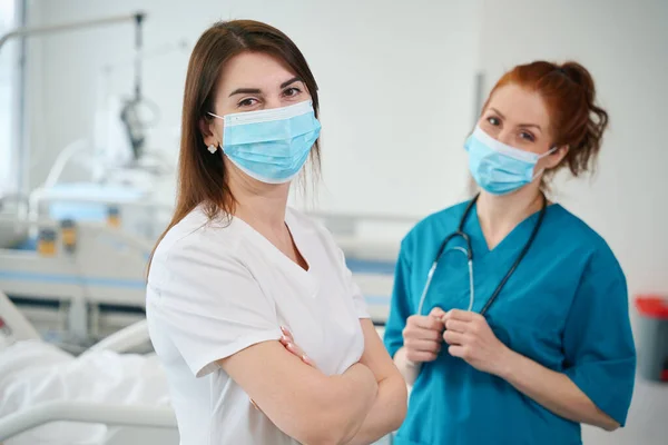 Portret Dwóch Pięknych Lekarzy Noszących Maskę Medyczną Mundur Stojących Oddziale — Zdjęcie stockowe
