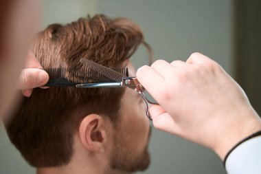 Berberin ellerinde kırpılmış manzara, kuaförde makas ve tarak kullanarak ziyaretçinin saçına yeni bir bakış getiriyor.