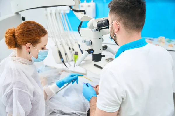 Doctor Dentist His Red Haired Assistant Workplace Doctor Uses Microscope — Stock Photo, Image