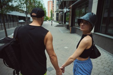 Genç bir kadın, erkek arkadaşıyla sokakta yürürken kameraya döndü.