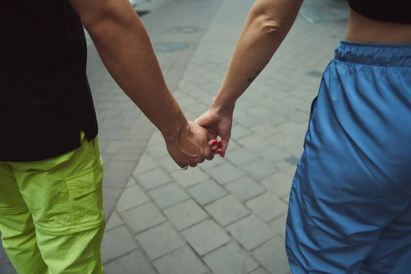 通りを歩いている間 お互いの手を握っているコーカサスカップルのクロップビュー — ストック写真