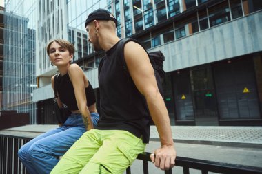 Güzel bir kadın erkek arkadaşıyla dışarıda vakit geçirirken kameraya bakıyor.