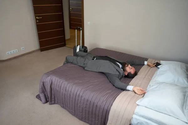 Yorgun Erkek Yolda Dinleniyor Otel Odasında Büyük Bir Yatakta Bir — Stok fotoğraf