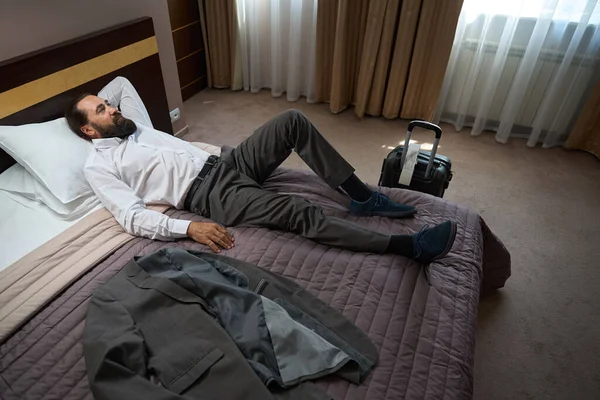 トラベラーは 柔らかい枕 旅行ジャケット スーツケースの道から休むために横たわります — ストック写真
