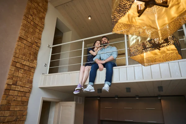 这对中年夫妇坐在房子二楼的楼梯平台上 室内使用环保材料 — 图库照片