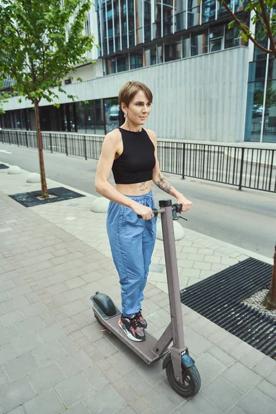 Brünette Sportbekleidung Fährt Mit Einem Roller Durch Die Straßen Der — Stockfoto
