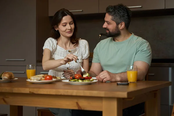 木のテーブルで居心地の良いキッチンで朝食でハッピーカップルチャット — ストック写真