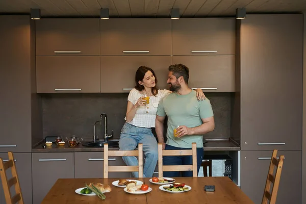 かわいい配偶者はキッチンで自宅にあり 朝食は木製のテーブルで提供されています — ストック写真