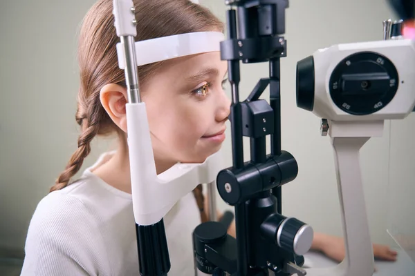 可爱的小女孩正在接受特殊装备的眼科检查 一个穿着休闲装的孩子 — 图库照片