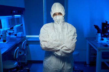 Steril üniformalı adam laboratuarda, modern ekipmanlar etrafta.