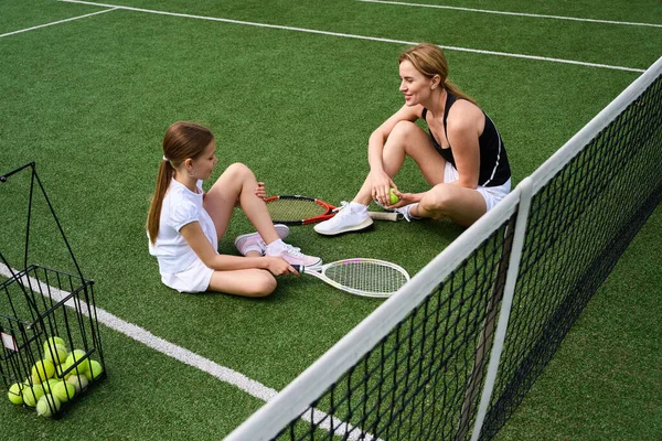 Vrouw Haar Dochter Rusten Het Gras Tennisbaan Hebben Tennisrackets Hun — Stockfoto
