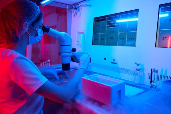 実験室のアシスタント胚科医 液体窒素を含むタンクの上に — ストック写真