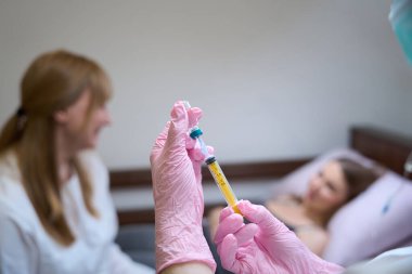 Doctor communicates with the patient in the hospital room, the nurse prepares the injection clipart