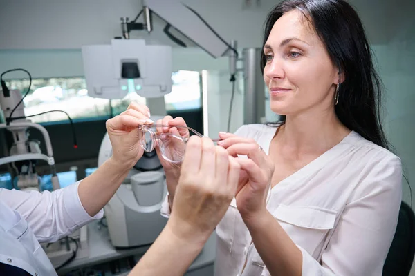 Nöjd Kvinnlig Klient Tar Nya Glasögon Från Optiska Dispenser Händer — Stockfoto