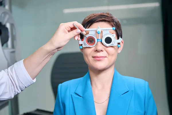 Kadın Hasta Ileriye Bakarken Optometrist Yüzündeki Deney Çerçevesi Hücresine Çapraz — Stok fotoğraf